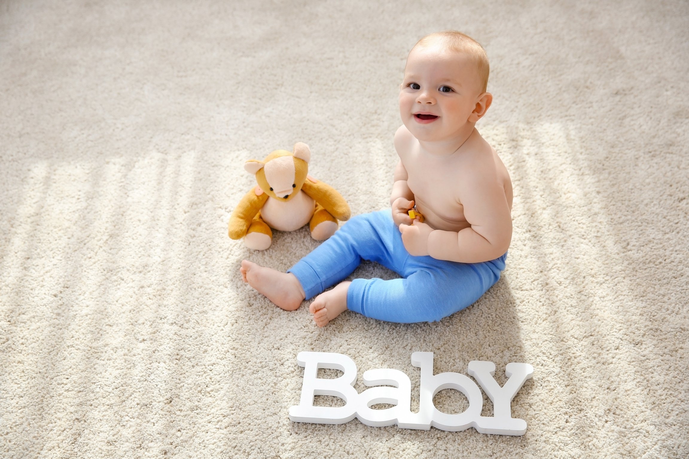 Baby Boy Playing with Teddy Bear on the Floor